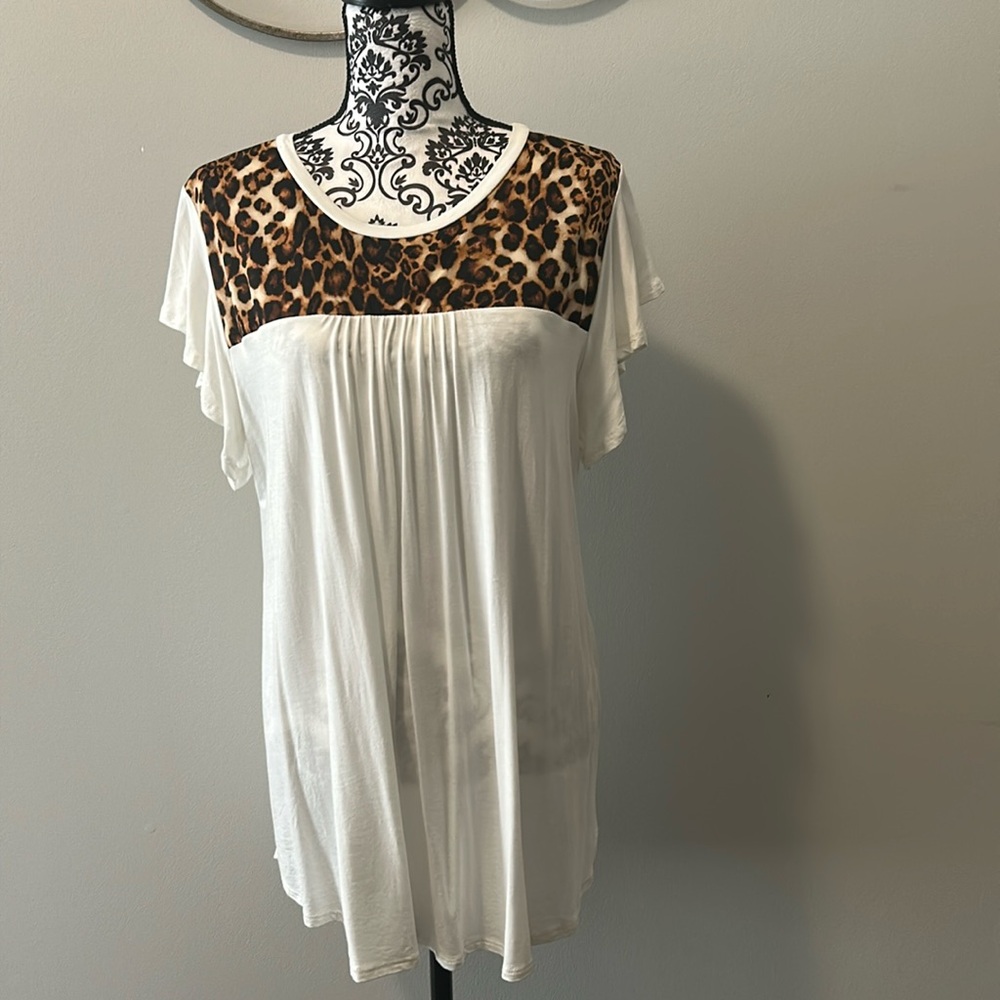 NWOT.  Woman’s cap sleeve t-shirt in cream with predator print neckline.